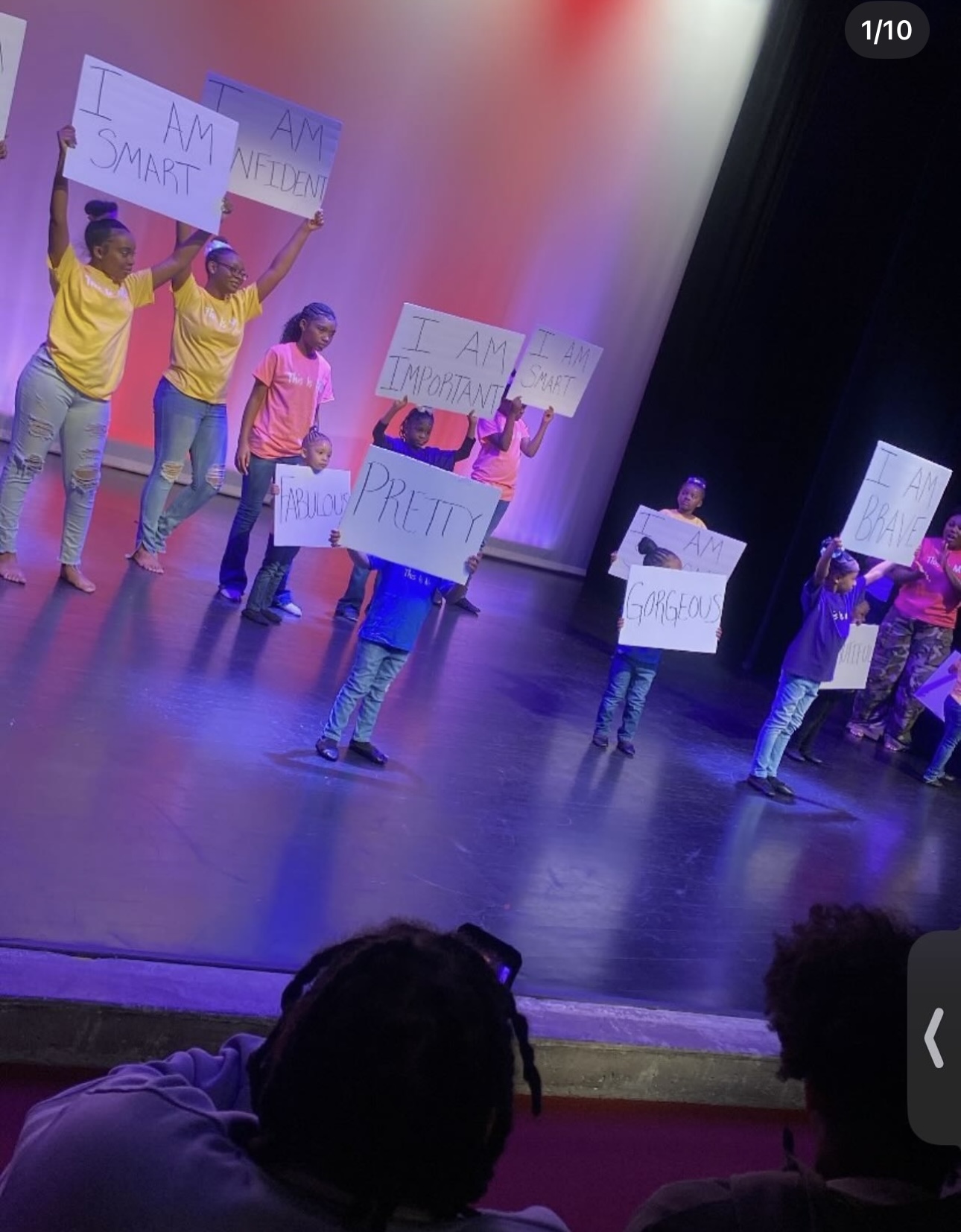 Dancers holding I Am affirmation signs